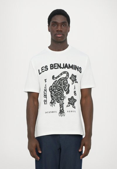 T-shirt en coton blanc avec un imprimé graphique noir d'un tigre et de fleurs, portant le texte "LES BENJAMINS ISTANBUL SEOUL" en dessous.