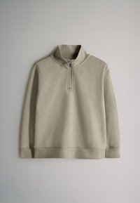 Svetlo bež dolgimi rokavi pulover z rebrastimi manšetami in spodnjim robom, z zadrgo na pol spredaj in rebrastim stoječim ovratnikom, položen na nevtralno ozadje.