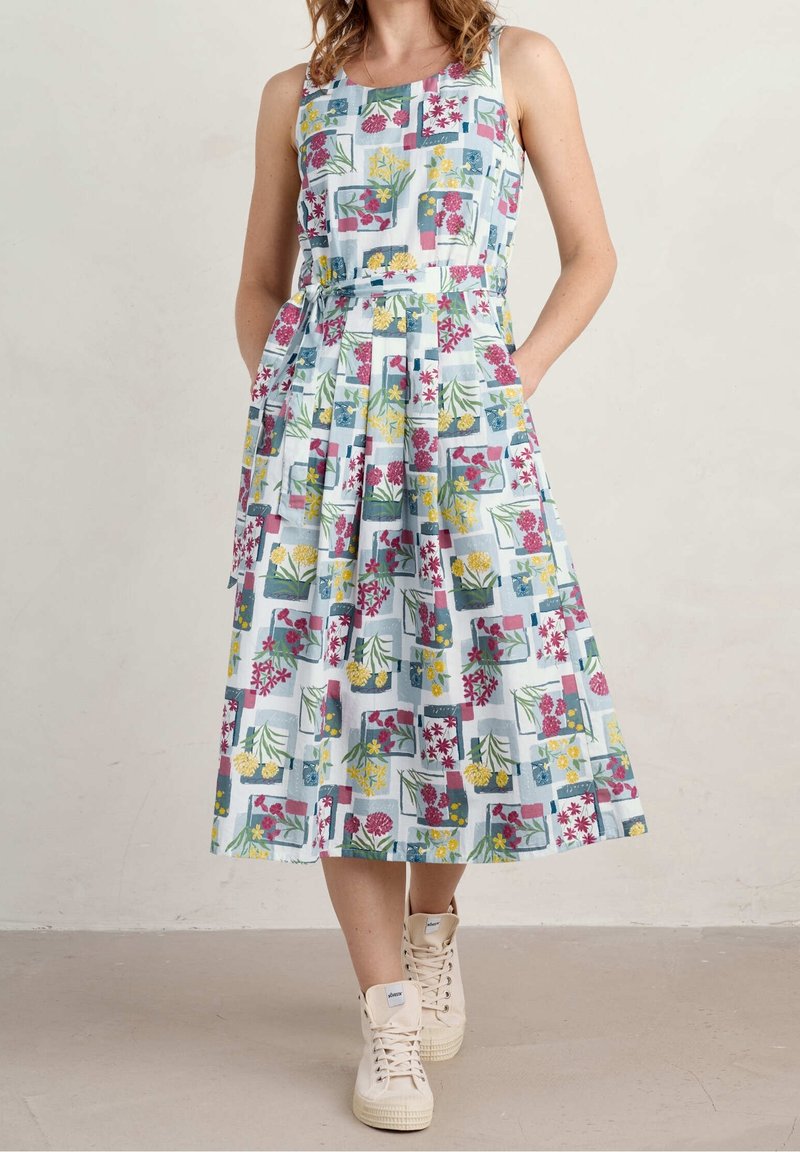 Robe midi à motif floral avec un fond bleu clair, design sans manches et jupe plissée, dotée de poches latérales et d'une ceinture en tissu.