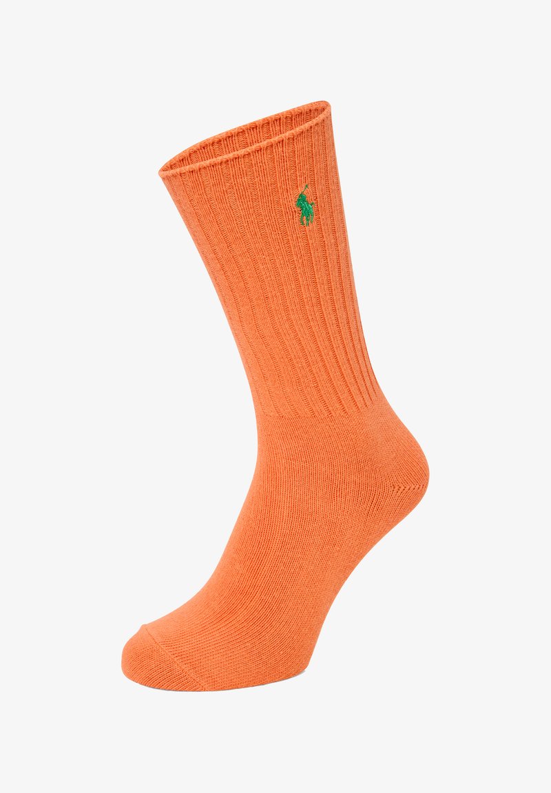 Oranje geribde sokken van een zachte stof, met een groen logo aan de zijkant en een ronde teenontwerp.