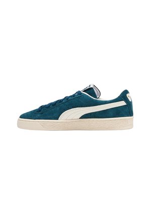 Sneaker in suede teal con una striscia in pelle bianca, suola in gomma crema e lacci blu, dotate di una suola testurizzata e di un'etichetta sulla linguetta.