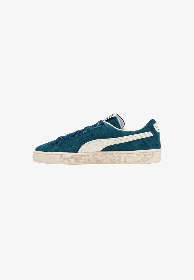 Sneaker in suede teal con una striscia in pelle bianca, suola in gomma crema e lacci blu, dotate di una suola testurizzata e di un'etichetta sulla linguetta.
