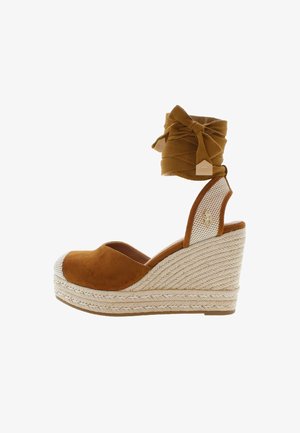 Brown suede wedge sandals with a woven jute platform, open toe, and adjustable knotted fabric ankle strap. Features a mesh accent on the heel.