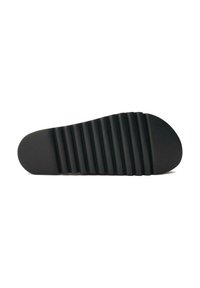 Black rubber shoe sole featuring horizontal grooves and a rounded toe, with a textured surface for grip and durability.