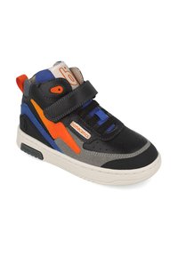 La zapatilla presenta una parte superior de cuero negro con acentos en azul y naranja, paneles grises texturizados, una correa de velcro y una suela de goma blanca.