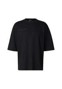 Černé volné tričko z bavlny. Má kulatý výstřih, krátké rukávy a potisk s textem na přední straně v kontrastní barvě.