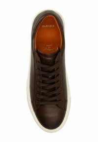 Bruine leren sneaker met ronde neuzen, witte rubberen zool en bijpassende bruine veters. Binnenzijde heeft een oranje voering; gelabeld "MANFIELD" op de tong.