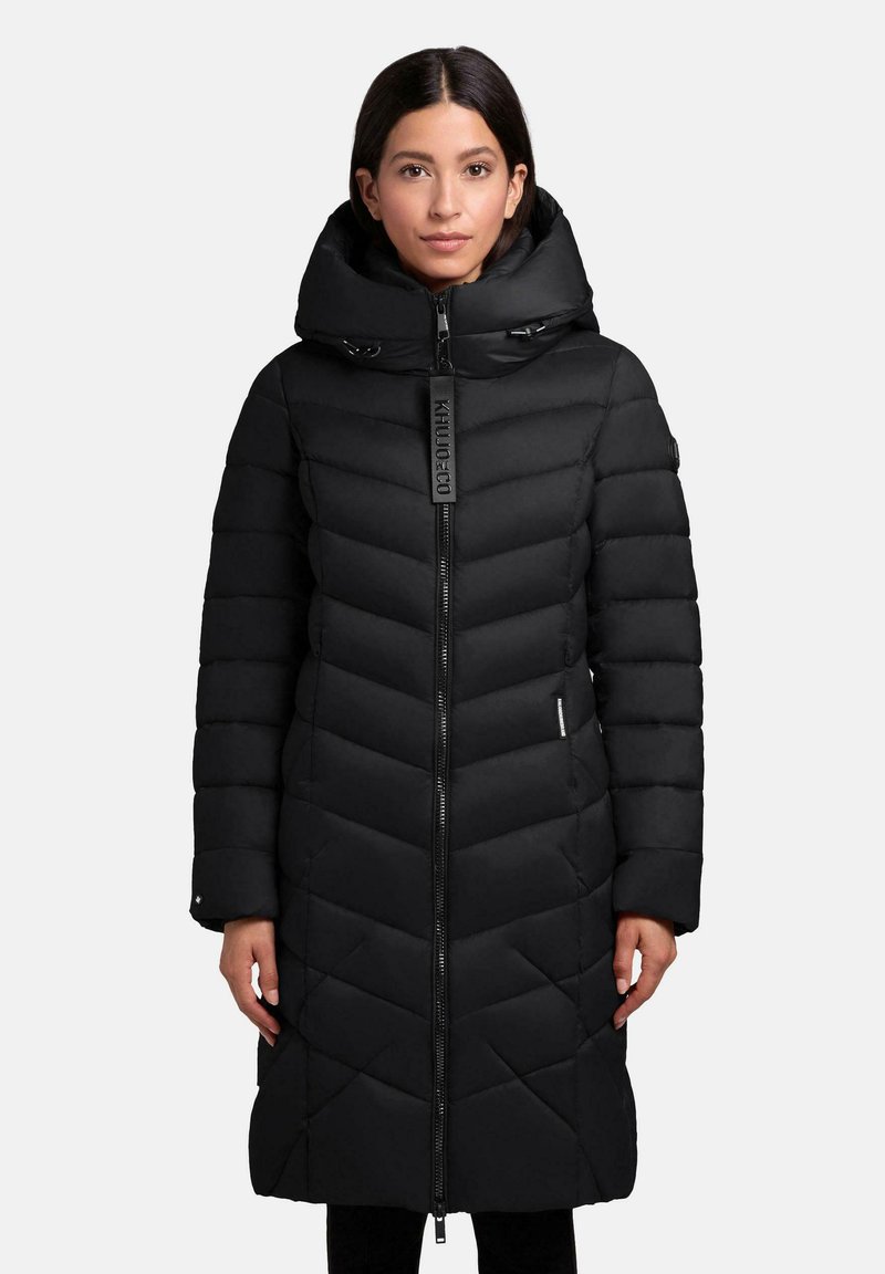 Sort pufferjakke med en chevron-design, høj krave og lynlås foran. Har en justerbar hætte og et elegant udseende.