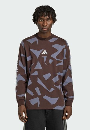 T-shirt marron à manches longues avec des motifs abstraits bleus. Doté d'un col rond et d'un logo sur la poitrine. Confectionné dans un tissu à la texture lisse.