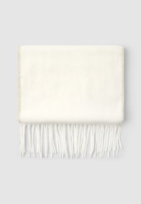 Foulard bianco morbido piegato con bordi frangiati e bordo cucito a zigzag su uno sfondo grigio chiaro.