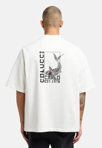 Witte oversized t-shirt met korte mouwen, voorzien van een gedetailleerde achterafbeelding van een koi-vis, met zwarte tekst "COLUCCI CARLO EST. 1978."