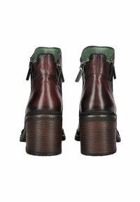 Bottines en cuir marron avec une finition texturée, fermetures éclair sur les côtés et un talon en bois empilé. Doublure intérieure verte visible.