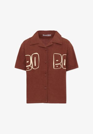 Short-sleeve brown button-up shirt with wide collar and bold beige abstract lettering across the chest.