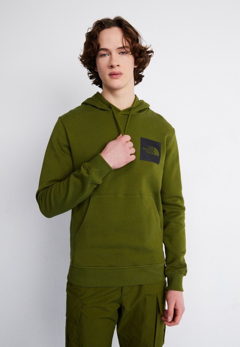 Felpa verde con cappuccio, dotata di tasca frontale e patch logo nero. Il tessuto sembra morbido; i polsini e il bordo in vita sono a costine per una vestibilità migliore.