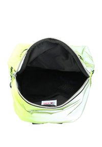 Borsa aperta nero e giallo neon con cerniera argentata, che mostra l'interno vuoto e l'etichetta Tommy Jeans all'interno.