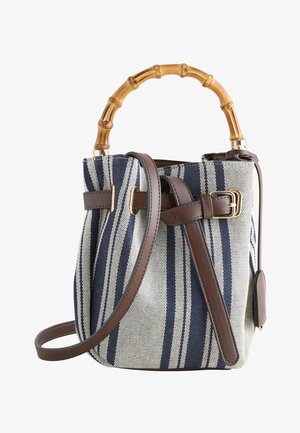 Blau-weiß gestreifte Stofftasche mit braunen Lederriemen, goldener Schnalle und gebogenem Bambusgriff auf weißem Hintergrund.