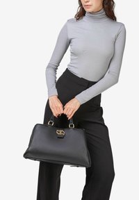 Sort lædertaske med guldfarvet hardware, struktureret form, top-håndtag, med lukning ved spænde og tekstureret overflade.