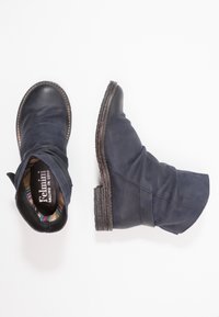 Botines de cuero azul marino con un diseño arrugado, suela texturizada y un forro de colorido patrón. Presenta un bajo tacón apilado.