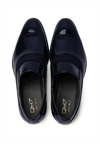 Zapatos de charol azul marino tipo slip-on con una superficie lisa, banda elástica en el empeine y forro interior acolchado.