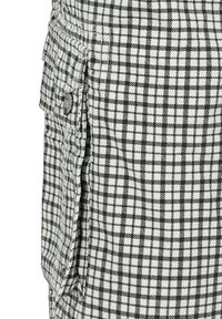Black and white checkered fabric with a textured surface, featuring functional side pockets and a button accent on the edge.