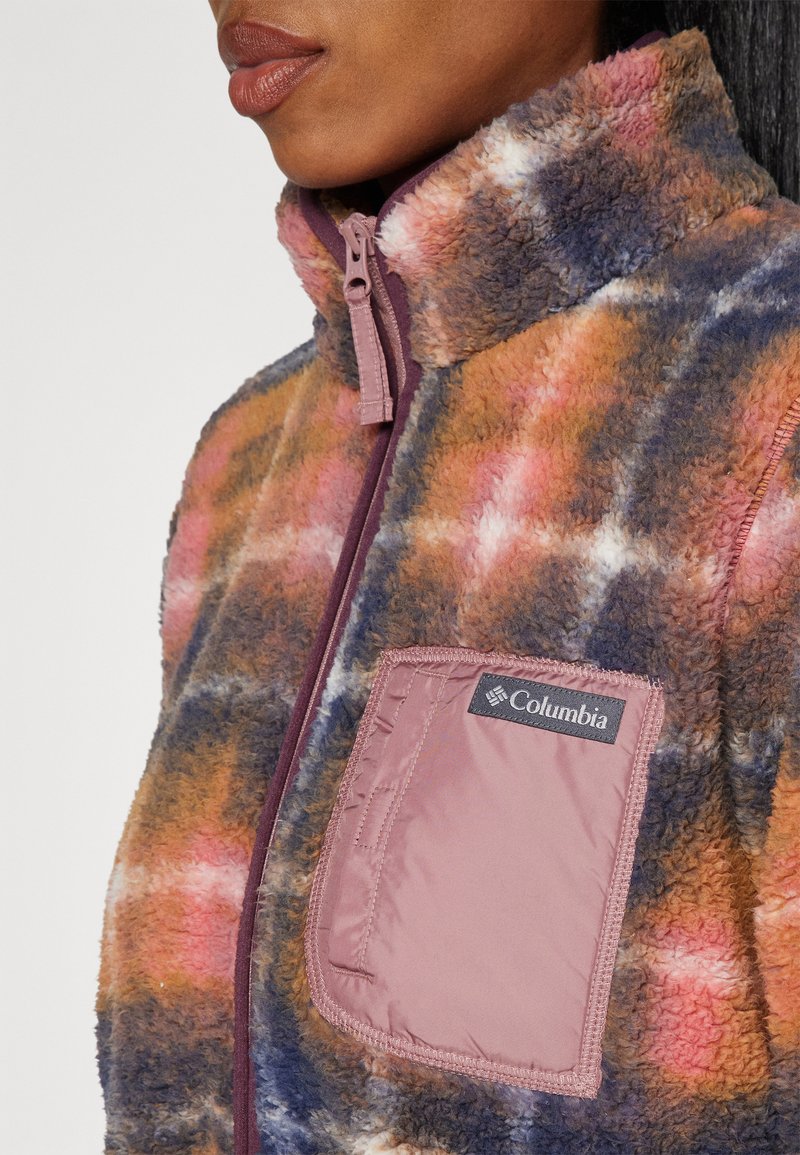 Veste en polaire à motif écossais multicolore avec un col haut, une fermeture éclair frontale et une poche en tissu contrasté avec le logo Columbia.