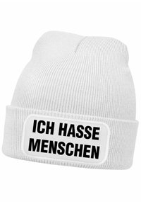White knit beanie with a soft texture, featuring a wide cuff. Displays black bold text on a rectangular patch: "ICH HASSE MENSCHEN."