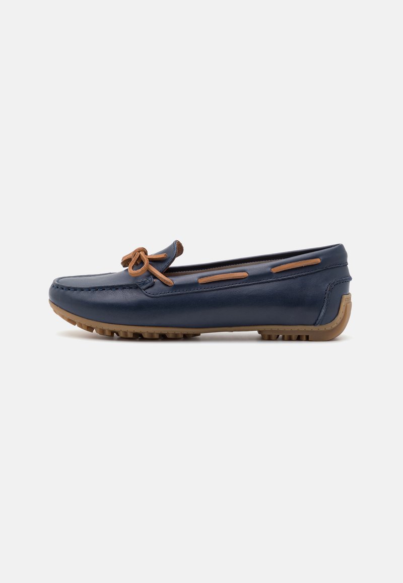 Mocassino in pelle blu navy con un accento di fiocco marrone, punta rotonda e suola in gomma testurizzata per grip e supporto.