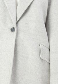 Cappotto in lana grigio chiaro con finitura testurizzata, dotato di rever a punta, chiusura a bottone singolo e tasca laterale.