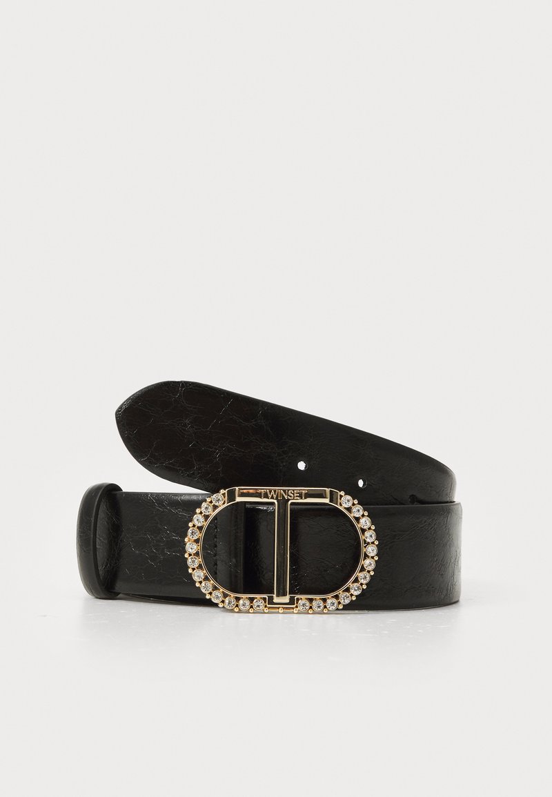 Black leather belt with a glossy finish, featuring a circular gold-tone buckle adorned with clear stones and a minimalist 'T' logo.