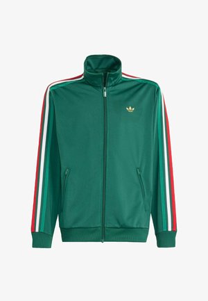 Giacca da pista verde con zip e colletto alto, presenta strisce rosse, bianche e verdi lungo le maniche e un piccolo logo dorato sul petto.