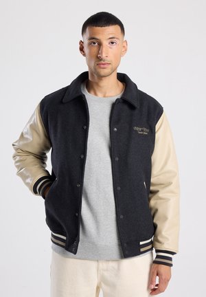 Veste de varsity en mélange de laine avec un corps noir, des manches en faux cuir beige, des poignets côtelés rayés et un détail brodé "NEW YORK" sur la poitrine.