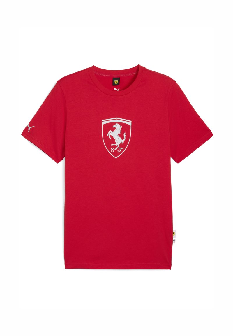 Rød T-shirt med korte ærmer, der har Ferrari-logoet i hvidt centreret på forsiden, samt et lille Puma-logo på venstre ærme.