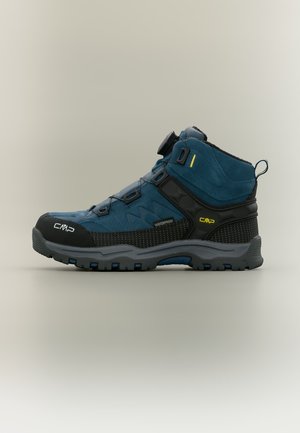 Blauwe en zwarte waterdichte wandelschoen met dikke grijze zool, snelvetersysteem en CMP-logo aan de zijkant en teen.