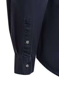 Marineblaue Hemdmanschette mit einem sauberen Knopfverschluss und einer glatten Textur sowie einer klaren Nahtdetails.