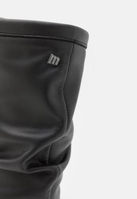 Stivale in pelle nera con una finitura texturizzata, caratterizzato da un design piegato e un piccolo accento con logo in metallo sul lato.