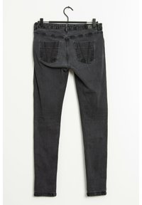 Svarta denim skinny jeans med en slät yta, med hög midja och två bakfickor, hängande på en galge mot en vit bakgrund.