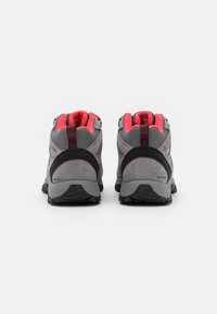 Szare buty trekkingowe z czerwonymi akcentami, górna część z teksturowanej zamszowej i siateczkowej tkaniny, wodoodporna konstrukcja, wyściółka wokół kostki, oraz wytrzymałe czarne podeszwy.