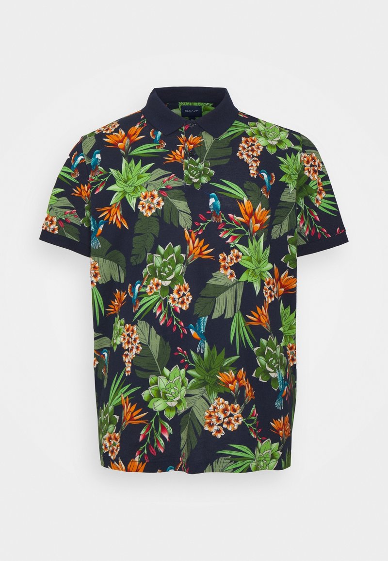 Polo bleu marine à manches courtes, présentant un motif de feuilles tropicales vertes, de fleurs orange et blanches, ainsi que de petits oiseaux bleus.