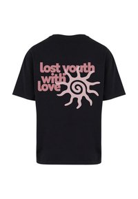 Černé bavlněné tričko s velkým růžovým potiskem, na kterém je nápis "ztracená mládež s láskou", a na zadní straně je design spirálového slunce.