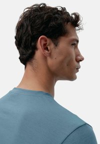 Kortsleeve, rundhalset t-skjorte i en dempet blå farge; glatt tekstur med svak melert mønster; har en ren finish ved halsen.