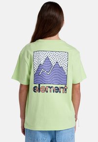 Camiseta de algodón verde claro con un gráfico de montaña morada y un fondo de lunares. La palabra "elemento" aparece en letras negritas y texturizadas.