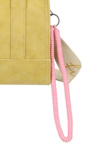Gelbe Wildlederhandtasche mit strukturierter Oberfläche, ausgestattet mit einem pinken geflochtenen Griff und einem beigen Gurt mit hellbeigen Schriftzug.