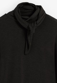 Top negro con una tela ligera y suave que presenta un detalle de bufanda anudada en el escote y mangas largas. Textura suave, diseño sencillo.