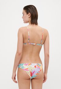 Wielokolorowy bikini z kwiatowym wzorem. Góra ma cienkie ramiączka, a dół ma niską talię z gładkim wykończeniem.