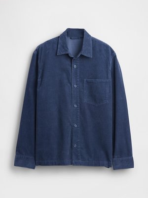 Chemise en velours côtelé bleu marine avec col, manches longues et une poche avant. Fermeture à boutons et tissu texturé.