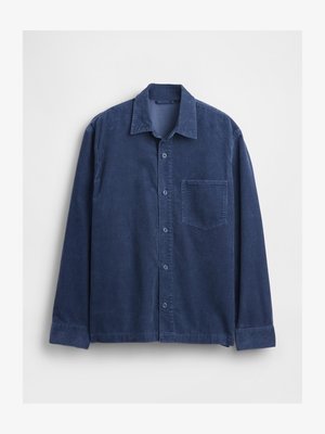 Tengerészkék kordbársony ing, galléros nyakkivágással, hosszú ujjal és elején zsebbel. Gombos záródás és texturált anyag.