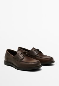 Brown leather shoes with a rounded toe, contrasting stitching, minimal lacing, and a textured sole for grip. Simple and classic design.