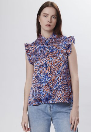 Korte mouwen blouse in oranje, blauw en wit met een palmbladpatroon, voorzien van gerimpelde capmouwen en een knoopsluiting aan de voorkant.