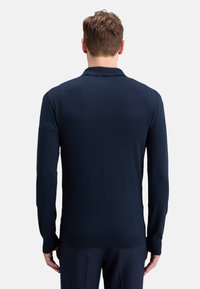 Suéter de manga larga azul marino con una textura suave y un cuello clásico. Presenta puños y dobladillo acanalados para un acabado ajustado.