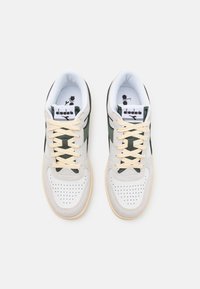 Hvite og grønne sneakers med overdel i teksturert lær, perforert tå, kremfargede snører og såle i gummi. Merkevarelogo på tungen.